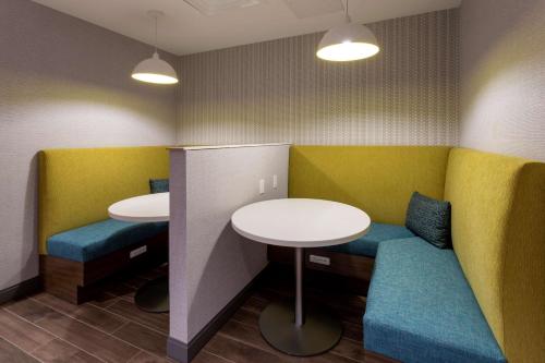 a waiting room with two tables and blue seats at Hampton Inn Eden Prairie Minneapolis in Eden Prairie