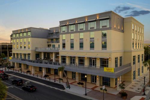 a building on a street with cars parked in front of it at Hilton Garden Inn Ocala Downtown, Fl in Ocala