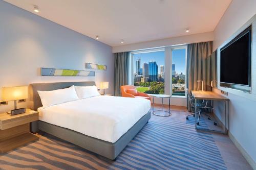 Doubletree By Hilton Perth Waterfront في بيرث: غرفة فندقية بسرير ونافذة كبيرة