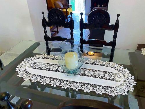 een glazen tafel met een kaars op een wit servet bij Casa da Avó Pipa in Reguengos de Monsaraz