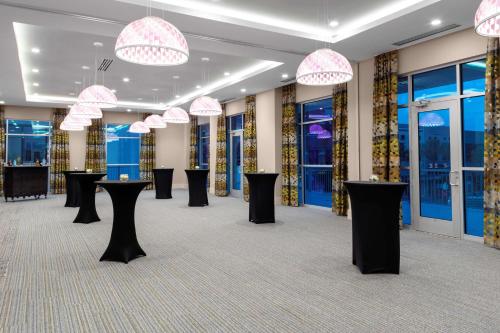 a room with black tables and pink chandeliers at Hilton Garden Inn Ocala Downtown, Fl in Ocala