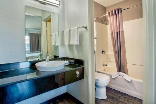 een badkamer met een wastafel, een toilet en een spiegel bij Motel 6-Salem, OR in Salem