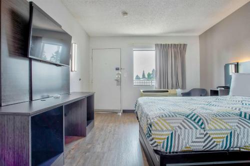 a hotel room with a bed and a large window at Motel 6-Salem, OR in Salem