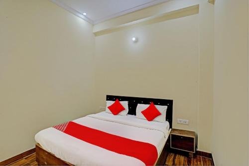 a bedroom with a bed with red and white sheets at Super OYO Flagship Sunrise Inn in Lucknow