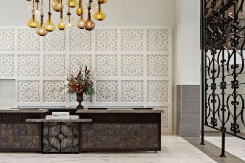 a lobby with a wall with white panels and a vase of flowers at The Cassara Carlsbad, Tapestry Collection By Hilton in Carlsbad
