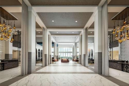 a lobby of a hotel with columns and chandeliers at The Cassara Carlsbad, Tapestry Collection By Hilton in Carlsbad