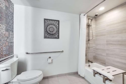 a white bathroom with a toilet and a shower at The Cassara Carlsbad, Tapestry Collection By Hilton in Carlsbad