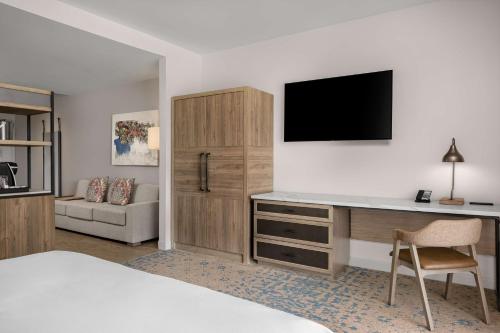 a hotel room with a bed and a desk with a television at The Cassara Carlsbad, Tapestry Collection By Hilton in Carlsbad