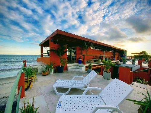 patio z krzesłami i dom na plaży w obiekcie Malibu Rooftop w mieście Nueva Gorgona