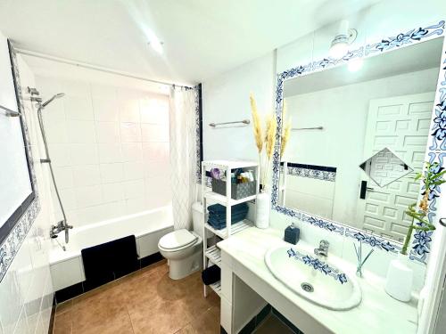 a bathroom with a sink and a toilet and a mirror at Marina Zahara in Zahara de los Atunes