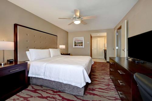 a bedroom with a bed and a flat screen tv at Homewood Suites by Hilton Albuquerque Airport in Albuquerque