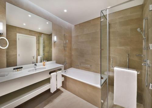 Un baño de Aleph Doha Residences, Curio Collection By Hilton