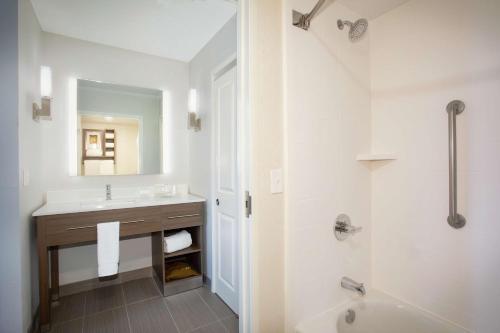 uma casa de banho branca com um lavatório e um chuveiro em Homewood Suites by Hilton Albuquerque-Journal Center em Albuquerque
