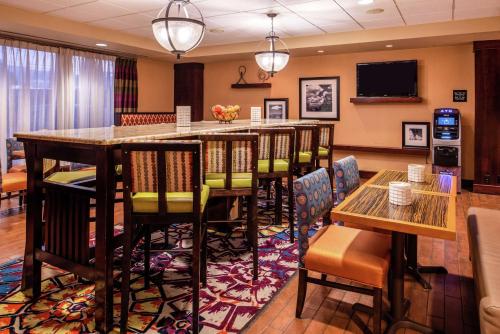 a restaurant with a bar with chairs and tables at Hampton Inn Albuquerque - University/Midtown in Albuquerque