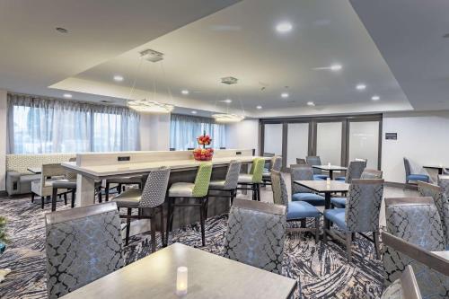 a dining room with tables and chairs and windows at Hampton Inn Waco North in Waco