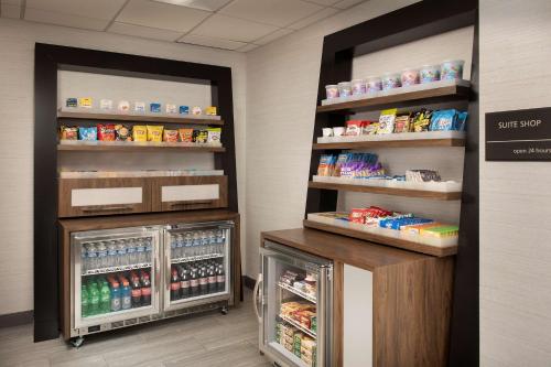 a store aisle with a refrigerator and shelves with food at Hampton Inn & Suites Alpharetta-Windward in Alpharetta