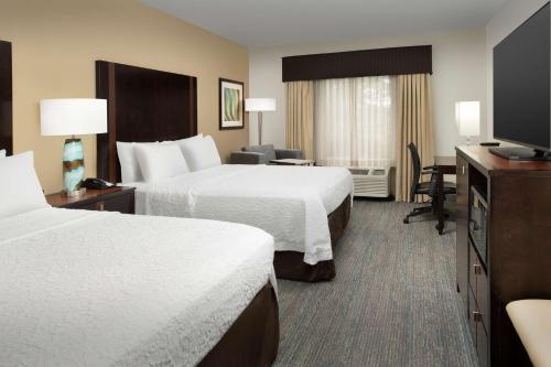 ein Hotelzimmer mit 2 Betten und einem Schreibtisch in der Unterkunft Hampton Inn & Suites Alpharetta-Windward in Alpharetta