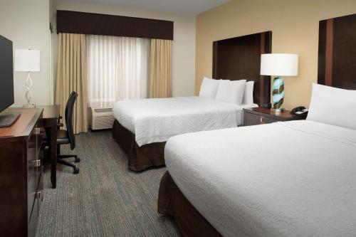 a hotel room with two beds and a desk at Hampton Inn & Suites Alpharetta-Windward in Alpharetta