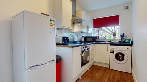 a kitchen with a refrigerator and a washing machine at Cosy 2 bed Apartment 1st Floor Business & Leisure Parking and Wifi by Jesswood Properties in Hinckley