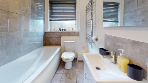 La salle de bains est pourvue d'une baignoire, de toilettes et d'un lavabo. dans l'établissement Cosy 2 bed Apartment 1st Floor Business & Leisure Parking and Wifi by Jesswood Properties, à Hinckley