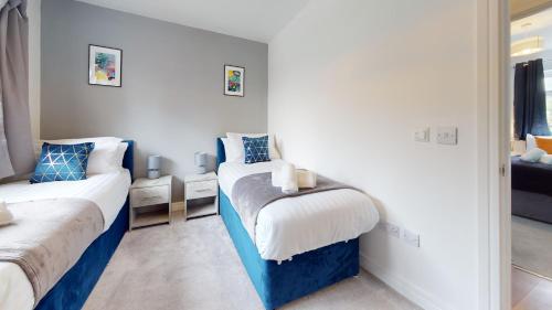 a bedroom with two beds and a mirror at Cosy 2 bed Apartment 1st Floor Business & Leisure Parking and Wifi by Jesswood Properties in Hinckley