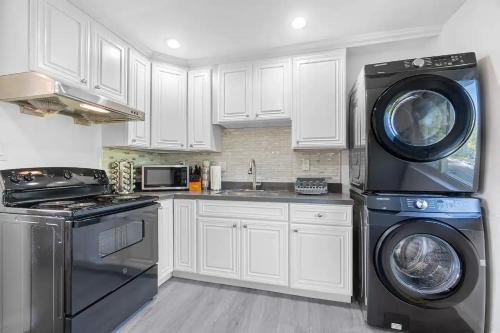 a kitchen with white cabinets and a washer and dryer at 2BR APT with AC, Washer, Dryer, EV Connector, Parking in Cupertino in Sunnyvale