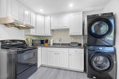 a kitchen with white cabinets and a washer and dryer at 2BR APT with Brand new super quite AC, Washer, Dryer, Free EV Station, Free Parking in Cupertino in Sunnyvale