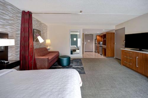 a hotel room with a bed and a flat screen tv at Home2 Suites by Hilton Nashville Vanderbilt, TN in Nashville