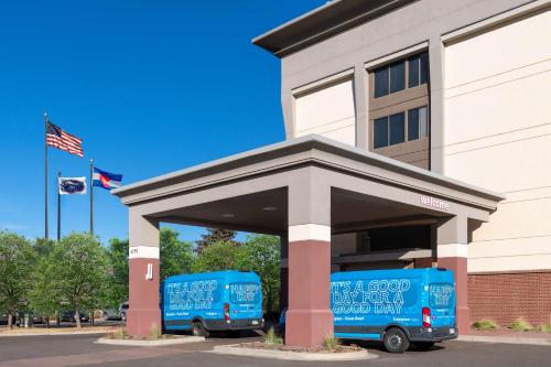 two blue vans parked in front of a building at Hampton Inn Denver-International Airport in Denver