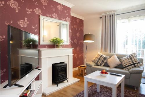 a living room with a couch and a fireplace at Rawmarsh House, Rotherham for contractors & Families, off-road parking, high speed wifi in Rotherham