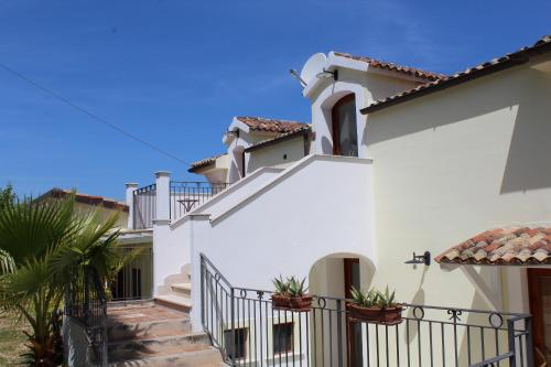 a white house with stairs and a fence at Albergo Villa Vittoria in Rodi Garganico