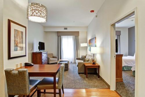 a living room with a table and a room with a bed at Homewood Suites by Hilton Oklahoma City-West in Oklahoma City