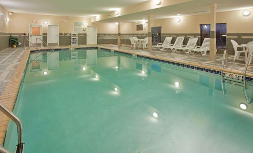 une grande piscine avec des chaises dans un hôtel dans l'établissement Hampton Inn and Suites St. Cloud, à Saint Cloud