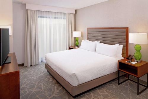 a hotel room with a bed and a television at Embassy Suites by Hilton Boston Marlborough in Marlborough