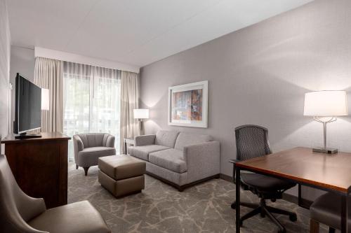 a living room with a couch and a desk and a television at Embassy Suites by Hilton Boston Marlborough in Marlborough