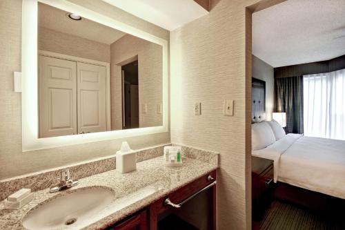 une salle de bain avec un lavabo et une chambre avec un lit dans l'établissement Homewood Suites by Hilton Atlanta-Galleria/Cumberland, à Atlanta