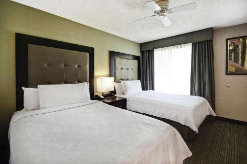 a hotel room with two beds and a window at Homewood Suites by Hilton Atlanta-Galleria/Cumberland in Atlanta