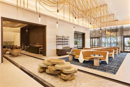 een lobby met banken en tafels in een gebouw bij Hilton Cancun, an All-Inclusive Resort in Cancun