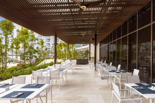 een restaurant met witte tafels en witte stoelen bij Hilton Cancun, an All-Inclusive Resort in Cancun
