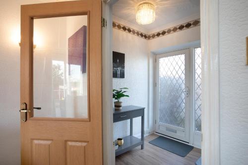 a door leading to a hallway with a table at Rawmarsh House, Rotherham for contractors & Families, off-road parking, high speed wifi in Rotherham