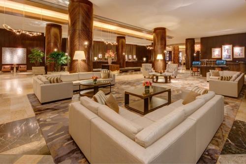 a lobby with couches and tables in a building at Hilton Americas - Houston in Houston