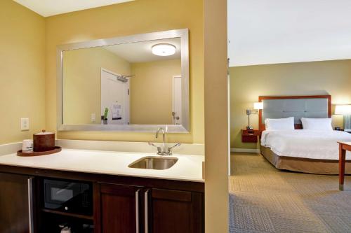 uma casa de banho com um lavatório e um quarto com uma cama em Hampton Inn & Suites Charleston Airport em Charleston