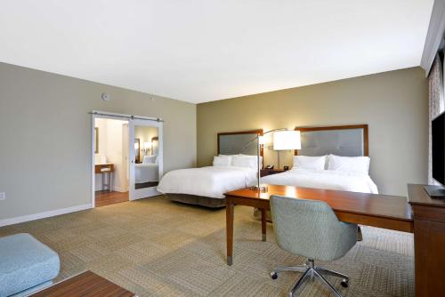 a large hotel room with two beds and a desk at Hampton Inn & Suites Charleston Airport in Charleston