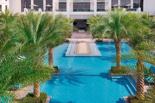 an aerial view of a swimming pool with palm trees at Hilton Abu Dhabi Yas Island in Abu Dhabi