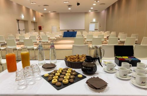 a table with food and drinks on it in a room at Best Western Plus Tower Hotel Bologna in Bologna