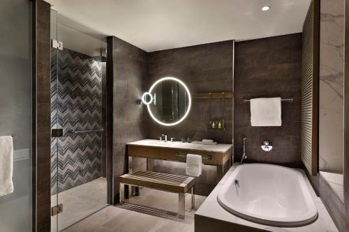 a bathroom with a tub and a toilet and a sink at Hilton Abu Dhabi Yas Island in Abu Dhabi