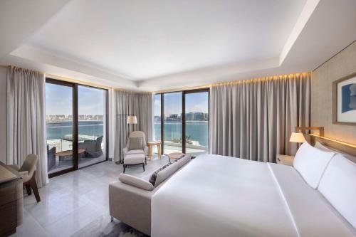 a hotel room with a large bed and large windows at Hilton Abu Dhabi Yas Island in Abu Dhabi