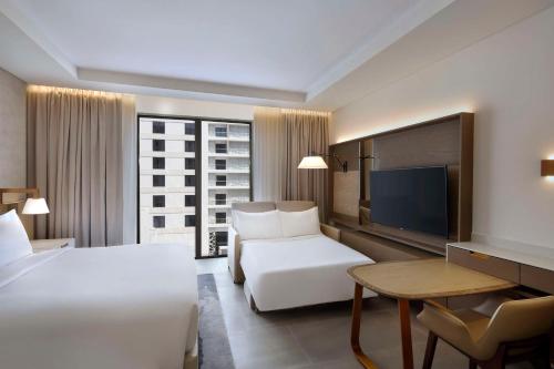a hotel room with two beds and a television at Hilton Abu Dhabi Yas Island in Abu Dhabi