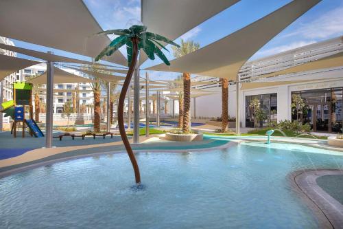 a palm tree in the middle of a swimming pool at Hilton Abu Dhabi Yas Island in Abu Dhabi