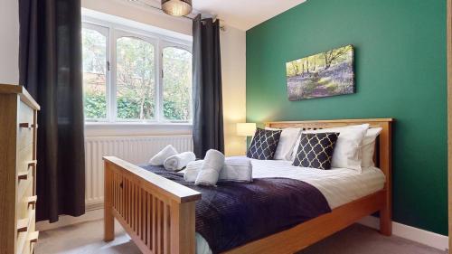 1 dormitorio con 1 cama con pared verde en Charming 3 Bed Bungalow Parking & Wifi Business and Leisure by Jesswood Properties, en Hinckley
